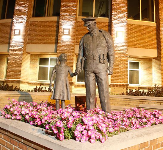 Statue of girl looking up to a police officer