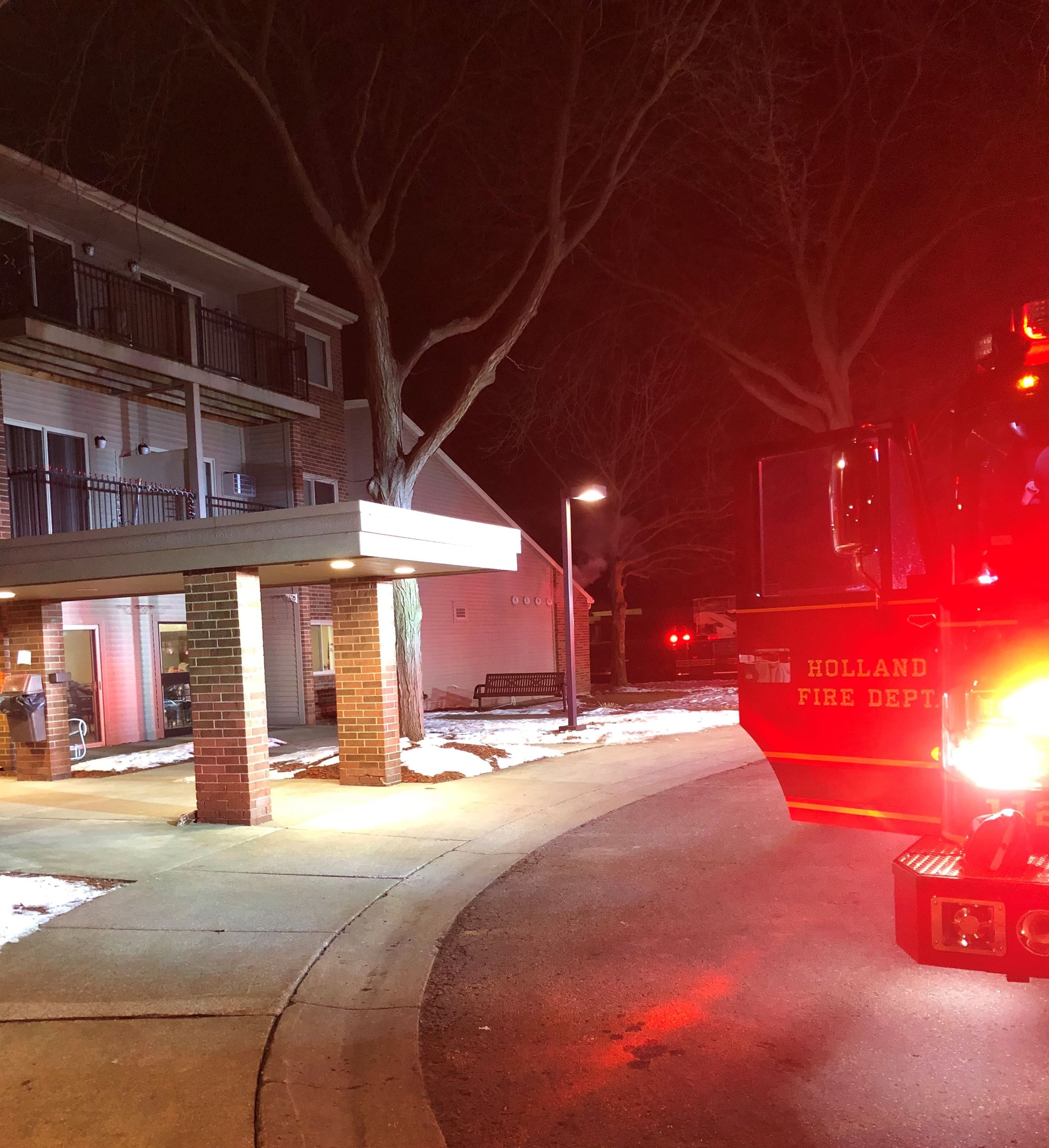 Fire truck with lights on in front of Apartment