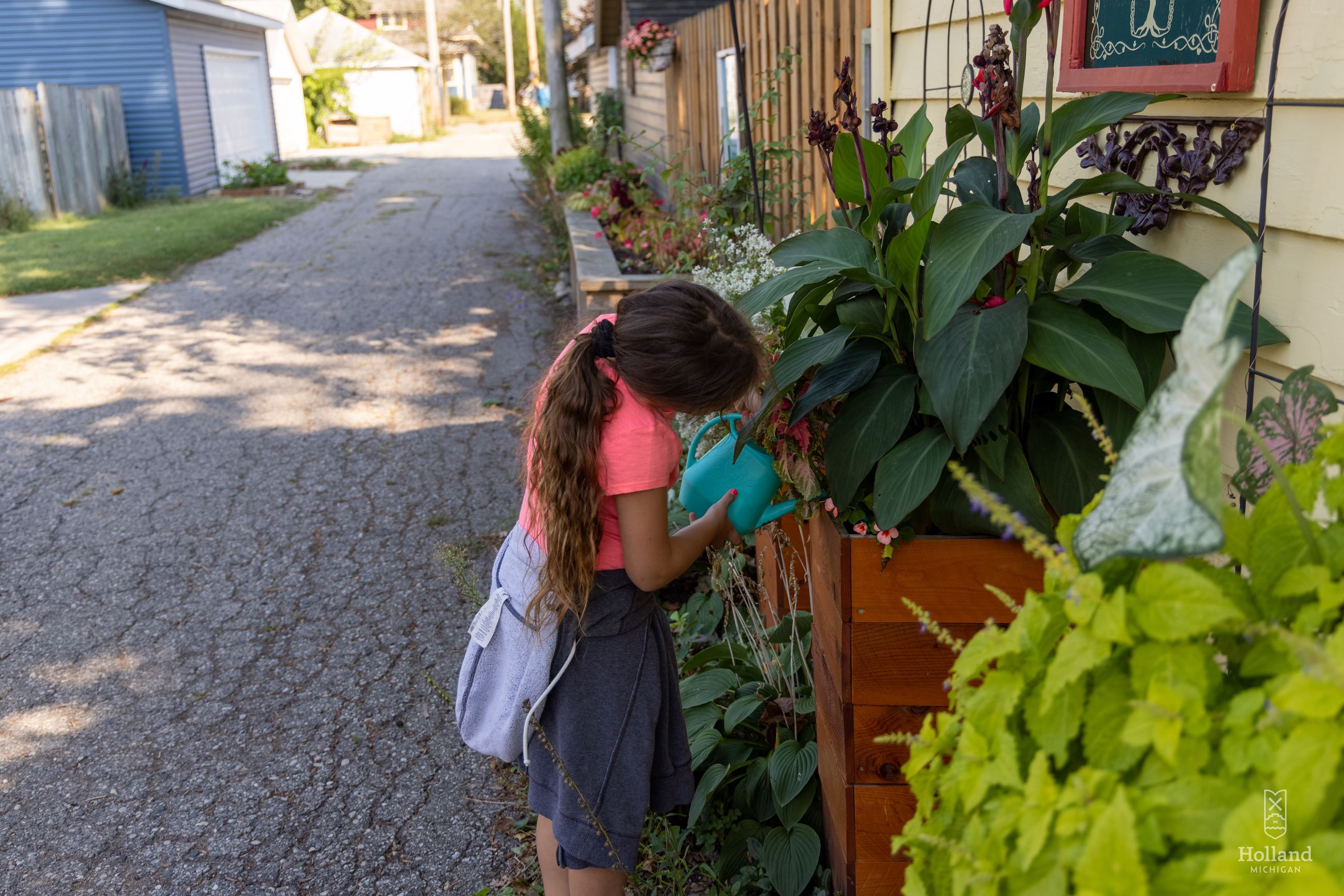 girl watering planter boxes