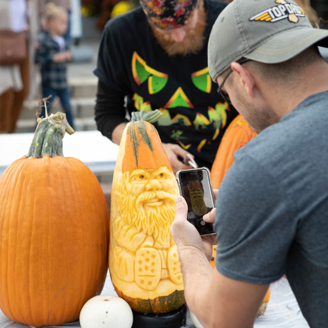 Man carving a pumpkin at Fall Fest
