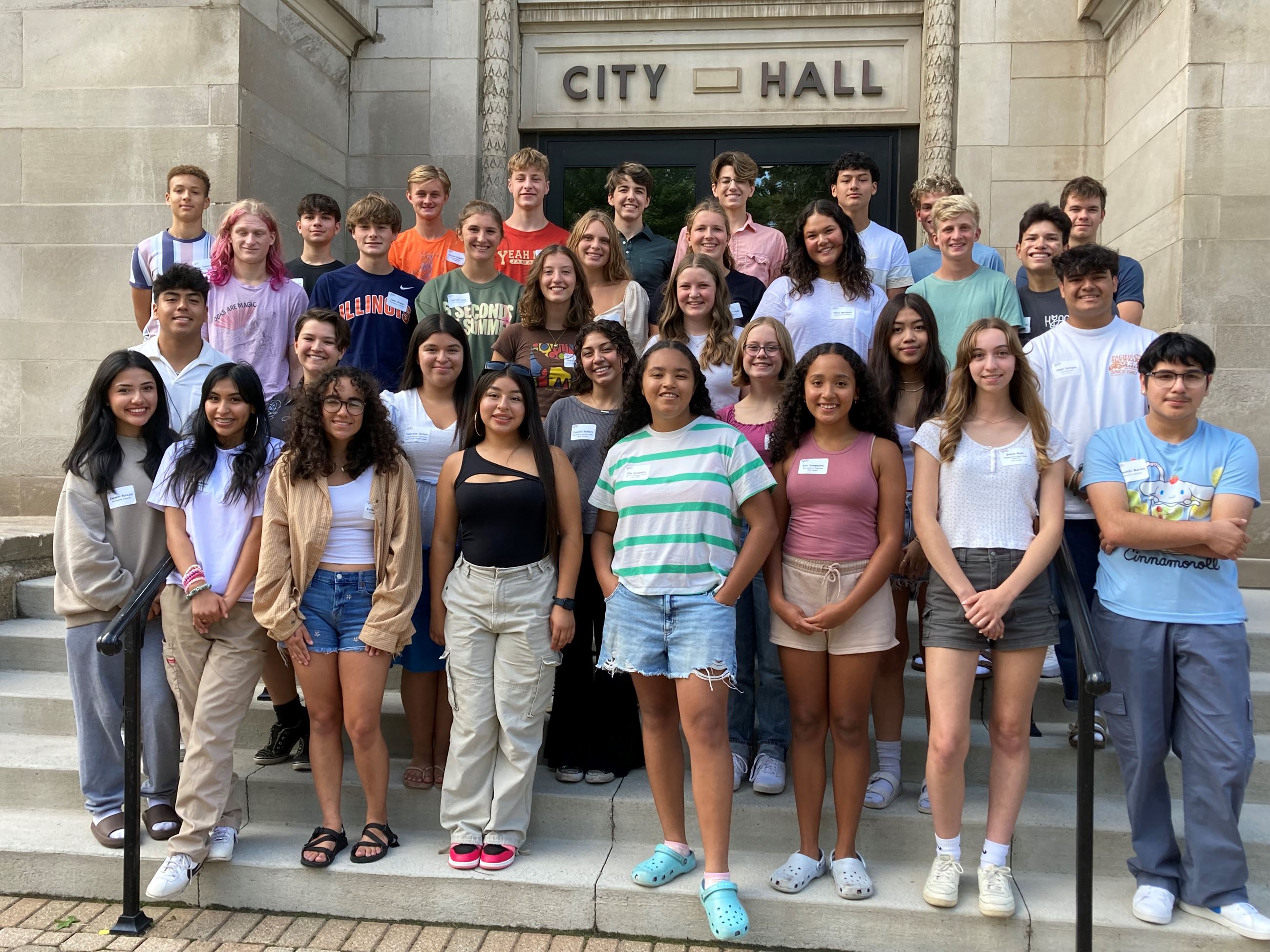 31 high school students standing on the front steps outside Holland City Hall