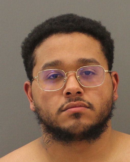 Male subject with black curly hair wearing glasses