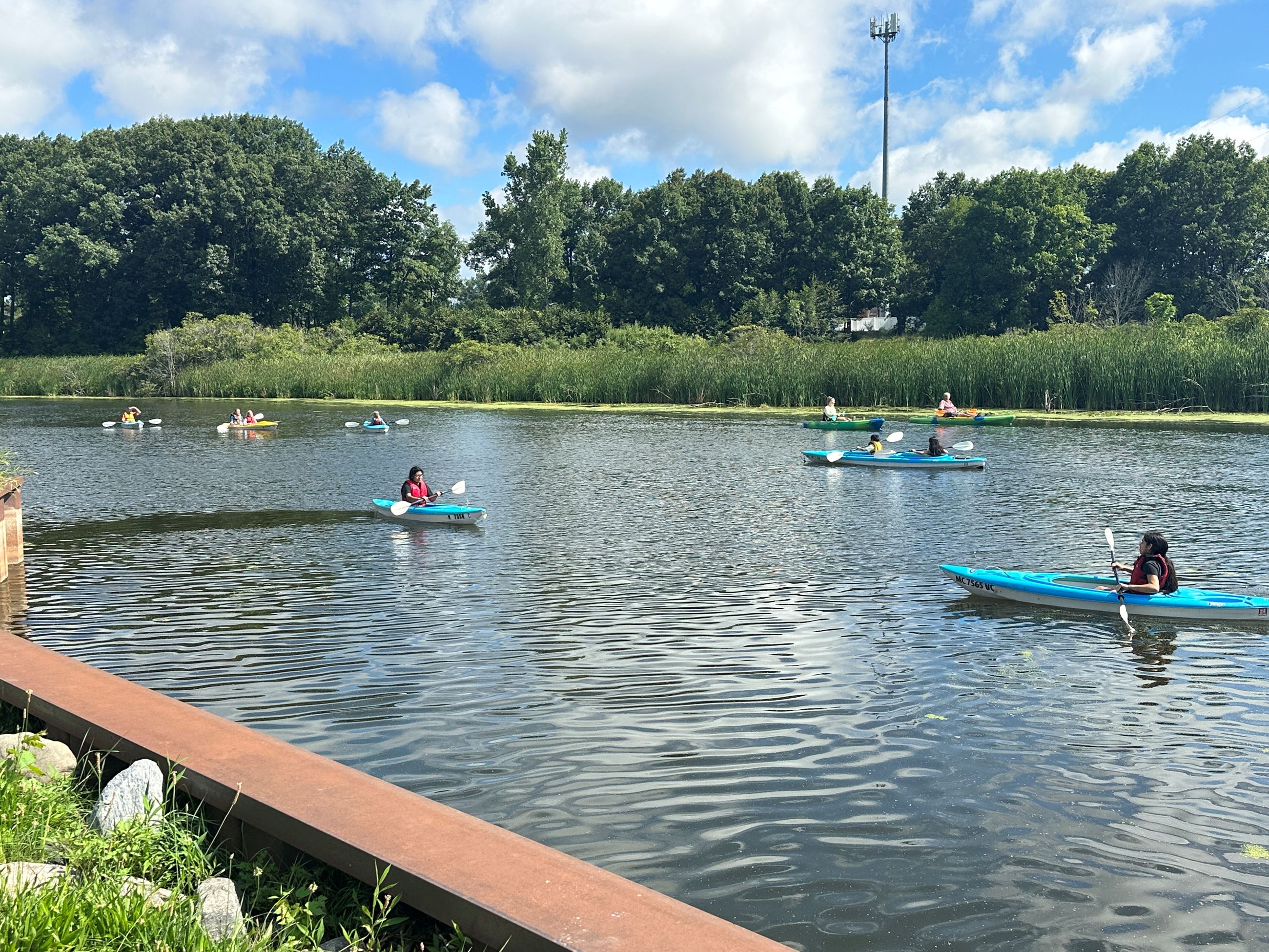 People in single kayaks paddling on a peaceful river 