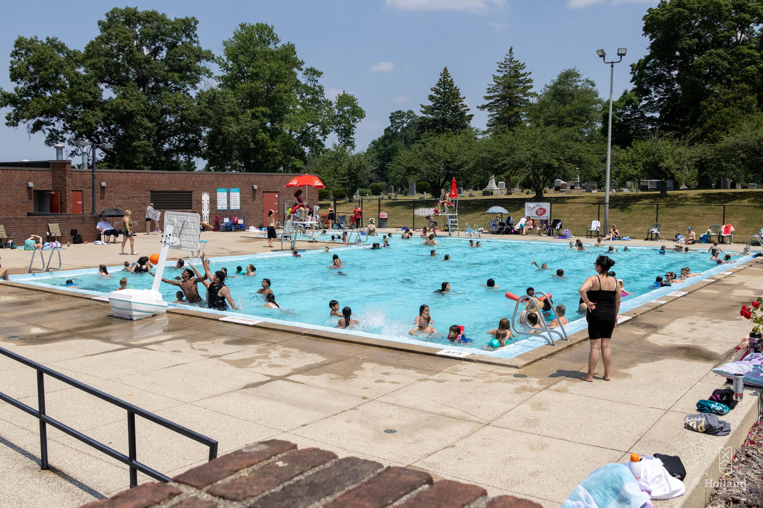 Outdoor swimming pool with people swimming for fun