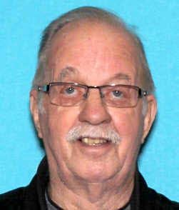 Older man with gray hair, glassing and a mustache 