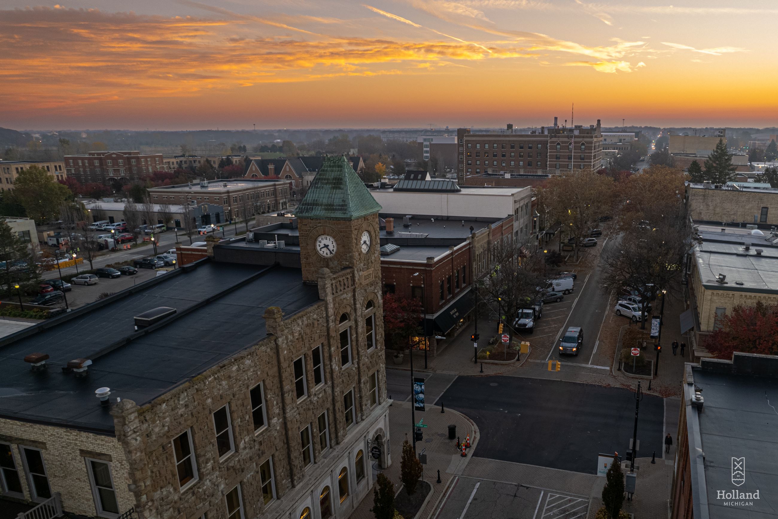 sunrise overlooking a downtown street with a clock tower building on the right side