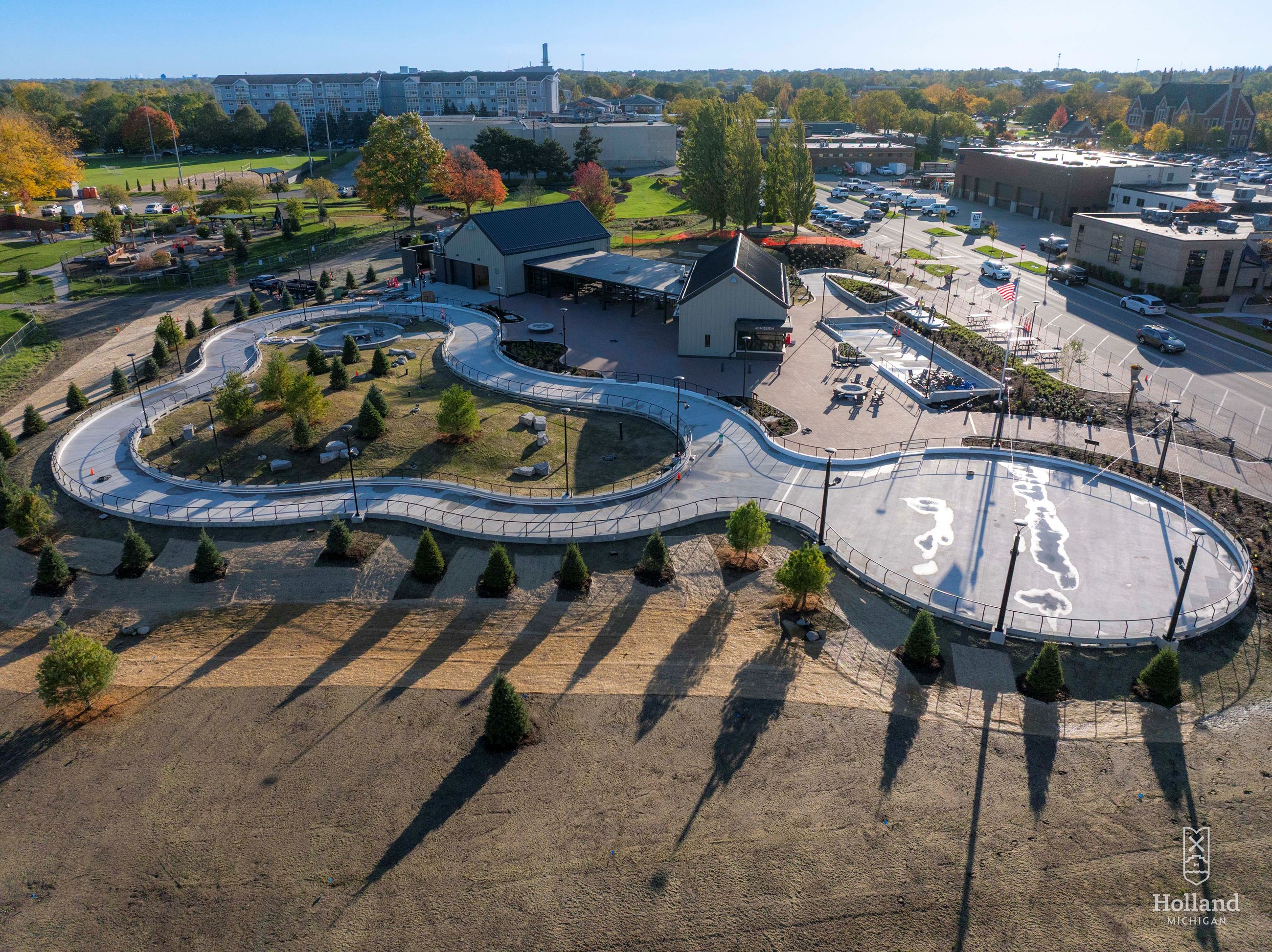 Ariel view of ice park with green trees and building the background