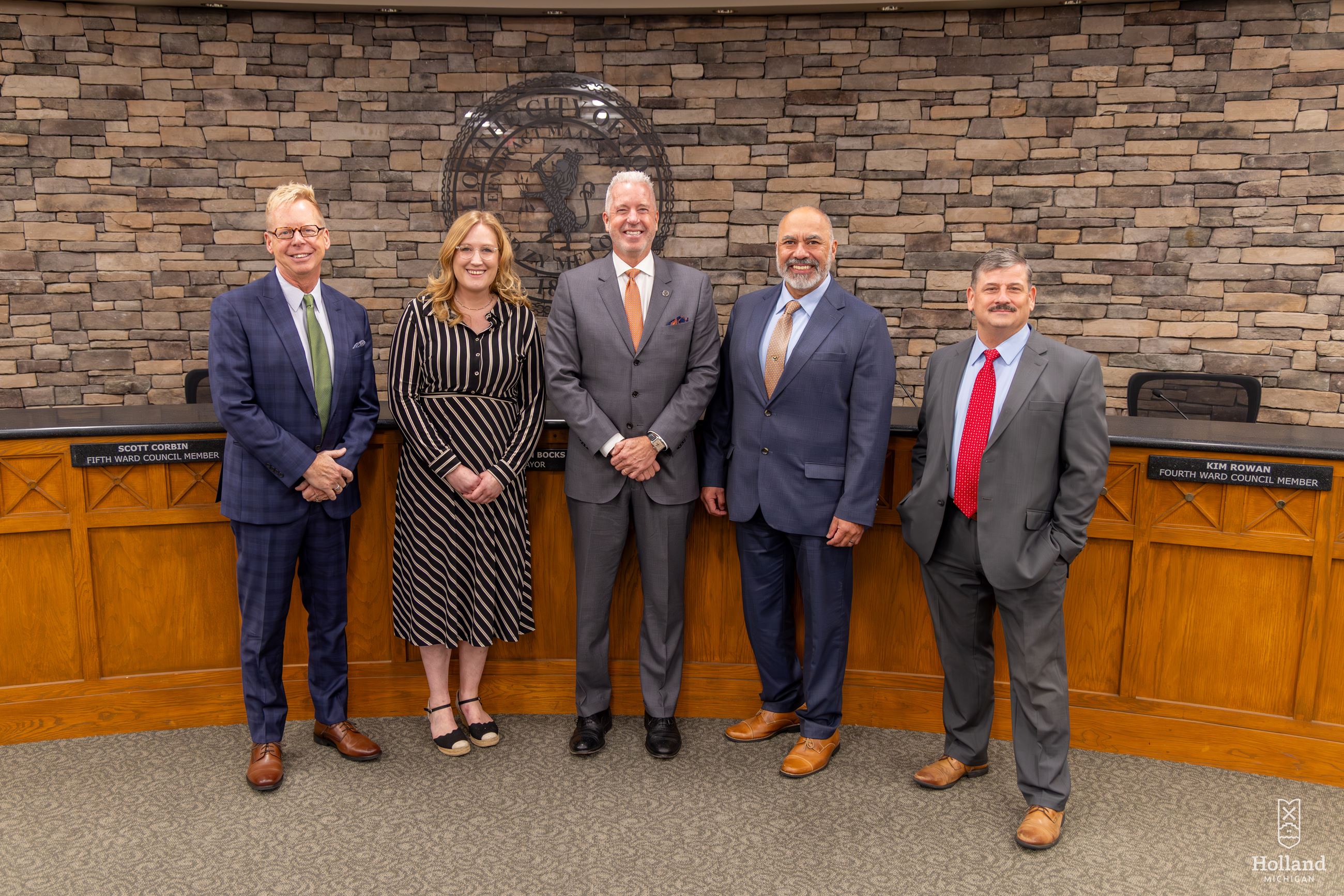 4 Men and 1 woman in business attire, standing in City Council chambers